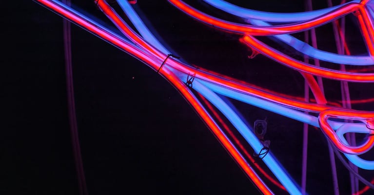 Abstract red and blue neon tubes intersect against a dark background, representing interconnected AI systems, digital networks and technology risk.
